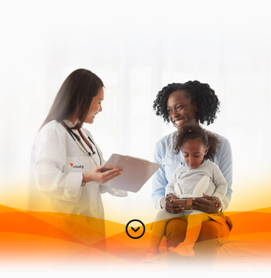 Vituity doctor smiling with patients who are mother and daughter