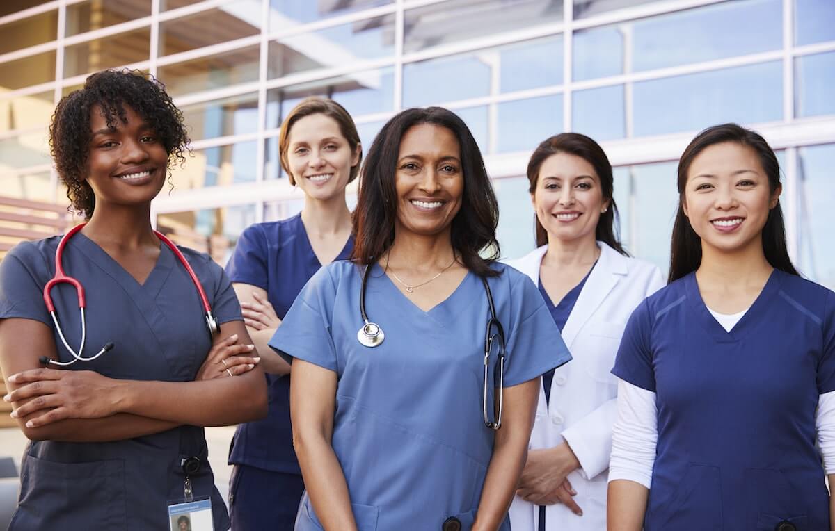 Team of women doctors and nurses in front of ER entrance